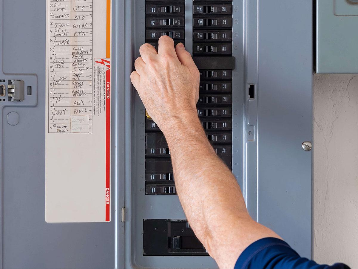 close up photo of a hand working in an electrical panel